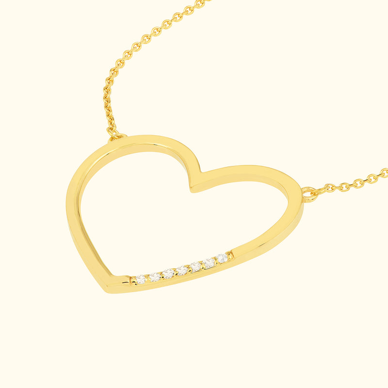 Gold heart pendant necklace with small diamonds along the bottom edge.