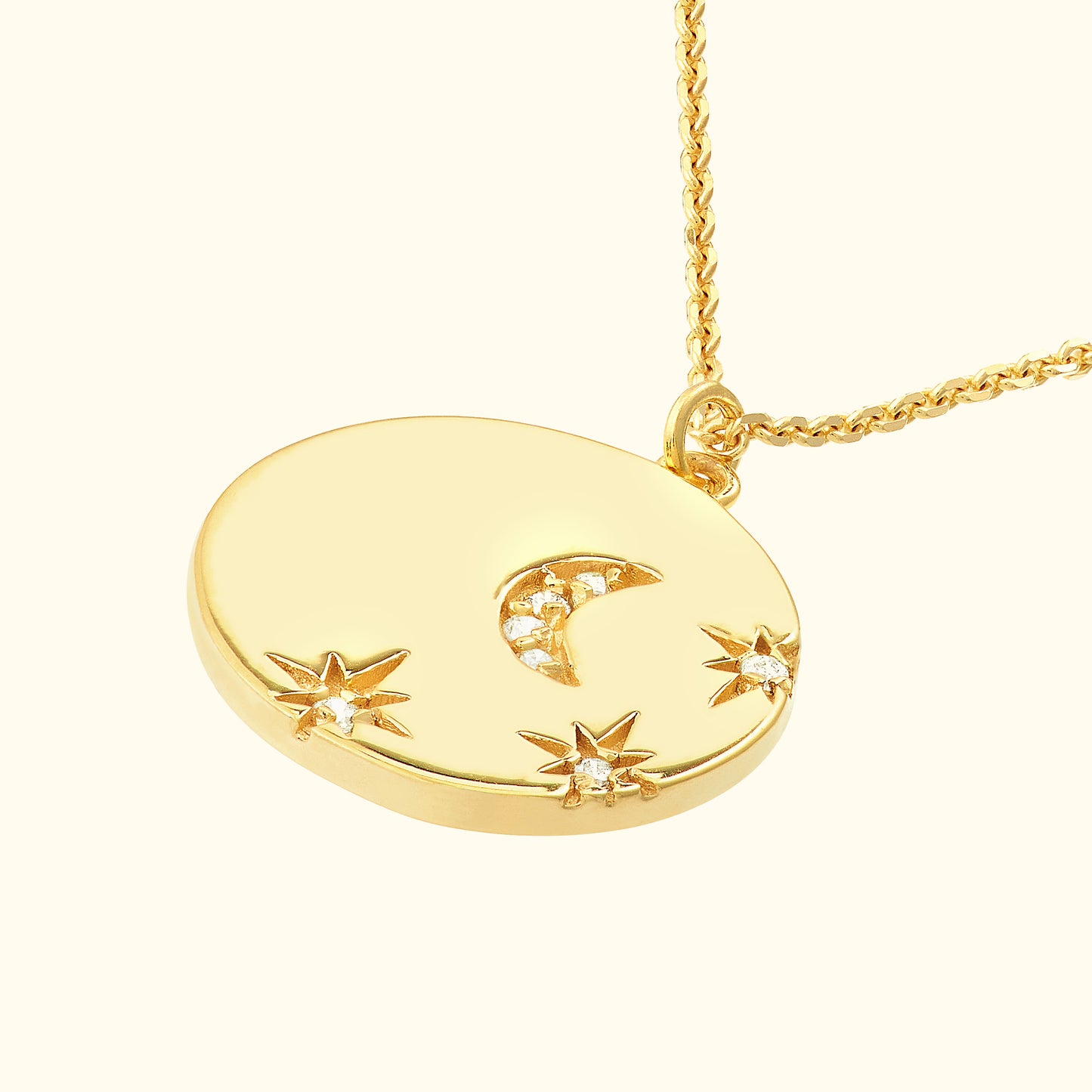 Gold pendant with a crescent moon and star motifs, embellished with small diamonds.