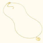 Delicate gold necklace with a round pendant featuring a crescent moon and star design.