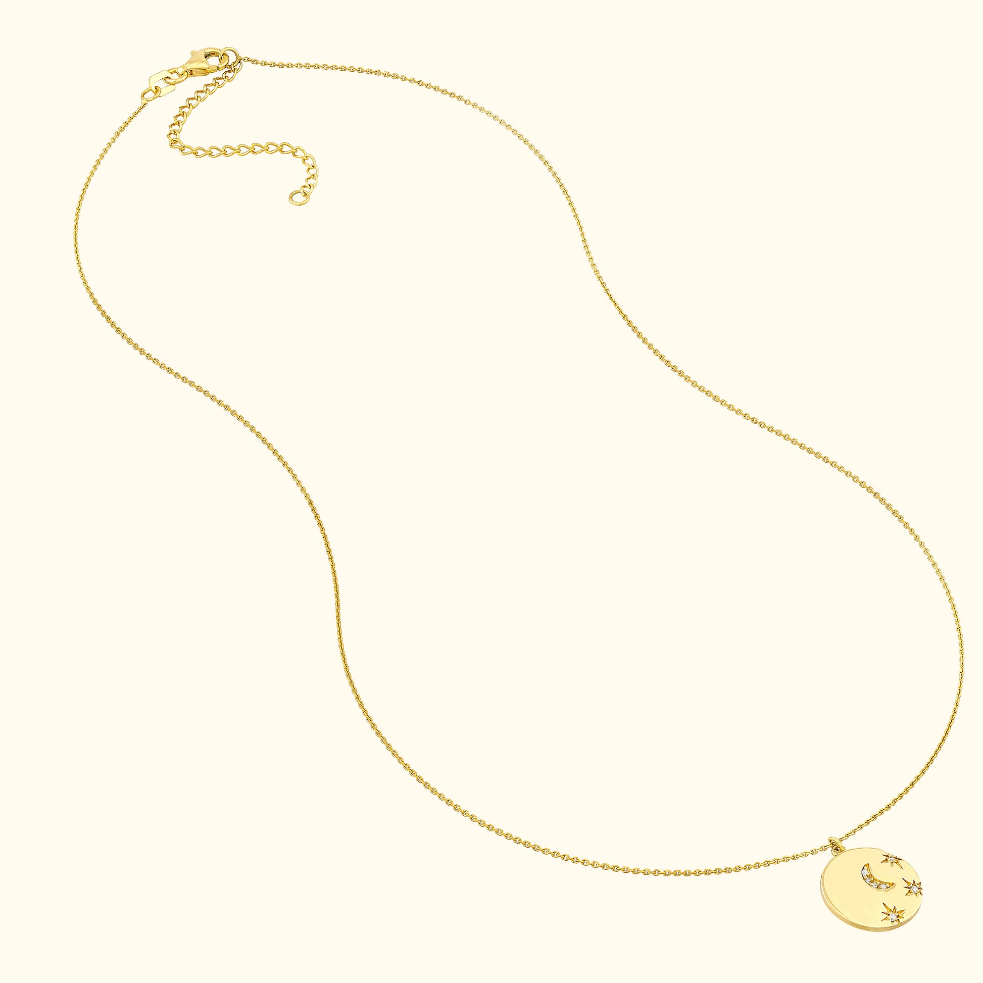 Delicate gold necklace with a round pendant featuring a crescent moon and star design.