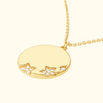 Gold pendant necklace with star accents and small diamonds.