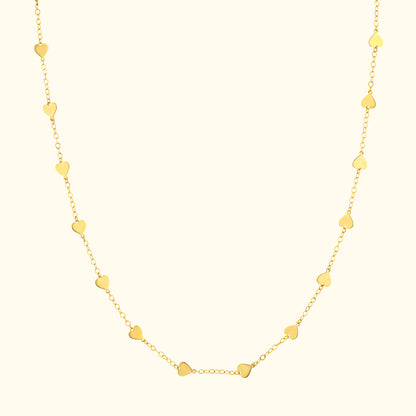 Gold chain necklace with small heart-shaped pendants interspersed along the length.