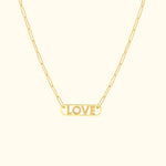 Gold necklace with a "LOVE" pendant on a delicate chain.