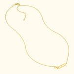 Delicate gold necklace featuring a unique safety pin design with a small diamond.