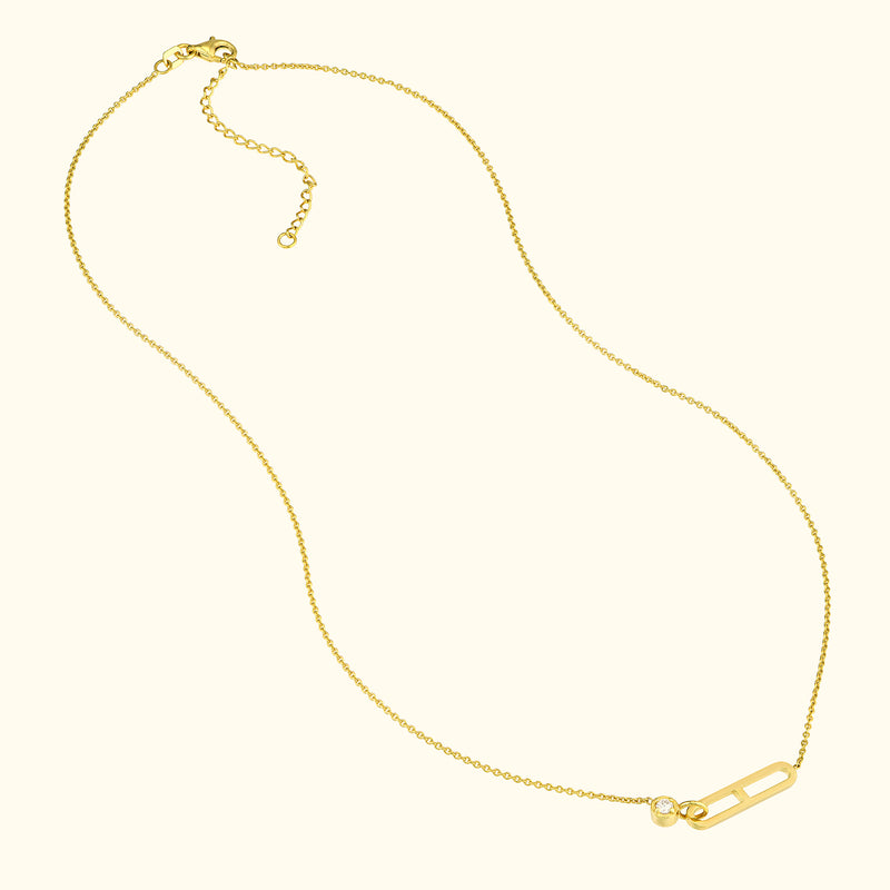 Delicate gold necklace featuring a unique safety pin design with a small diamond.
