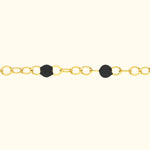 Gold chain necklace with black circular accents.