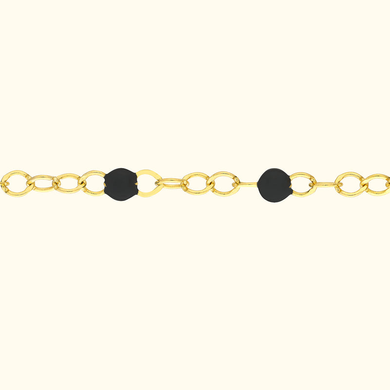 Gold chain necklace with black circular accents.