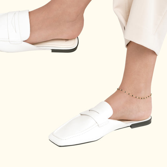 An ankle bracelet with small beads paired with stylish white loafers.