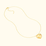 Gold necklace with a shiny heart-shaped pendant and a delicate chain.