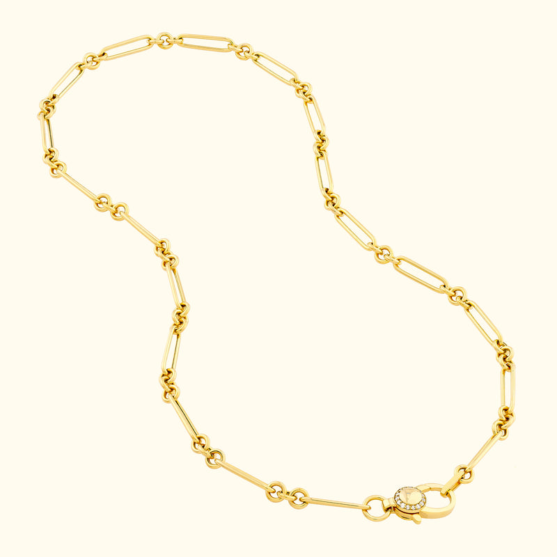 Gold chain necklace with oval links and a decorative clasp featuring a small diamond.