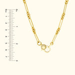 Gold chain necklace with a decorative clasp, accompanied by a ruler for size reference.