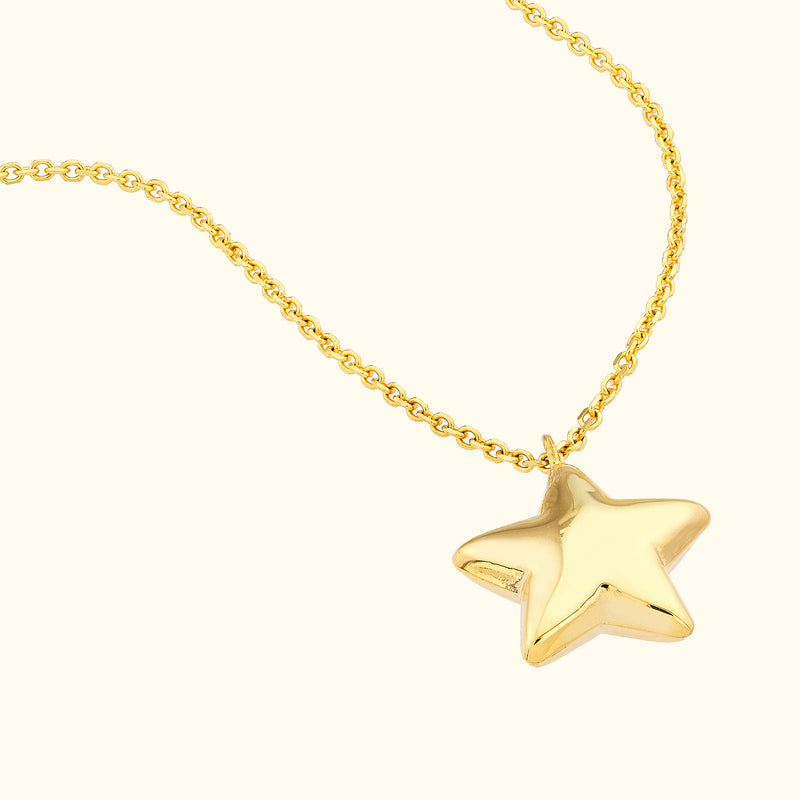 Gold star pendant necklace on a delicate chain.