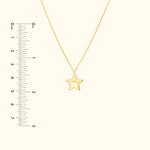 Gold star pendant on a delicate chain with a ruler for size reference.