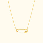 Gold necklace featuring a minimalist safety pin pendant on a delicate chain.