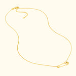 Delicate gold necklace featuring a safety pin charm.