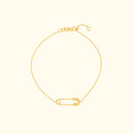 Gold chain bracelet featuring a decorative safety pin charm.