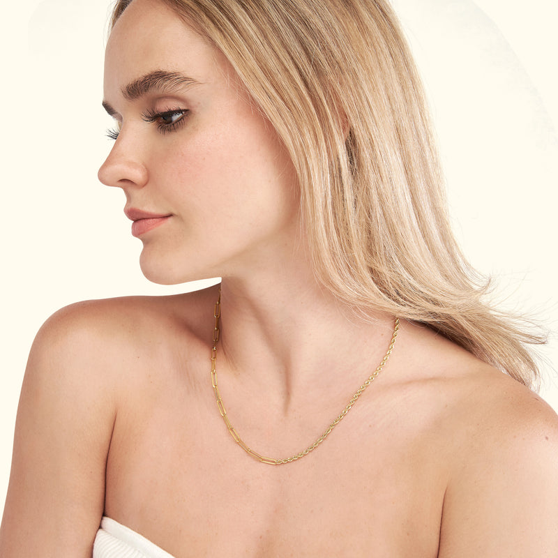 Elegant woman wearing a gold chain necklace, showcasing her profile.