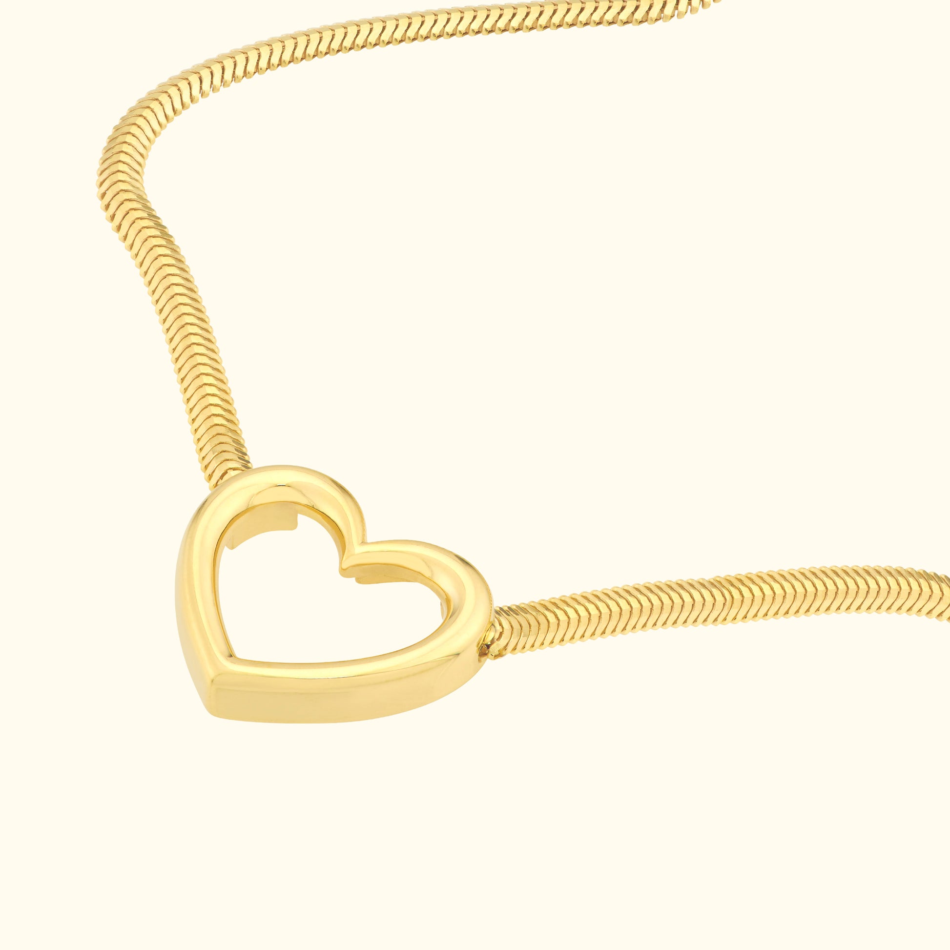 Gold heart-shaped pendant on a delicate snake chain necklace.