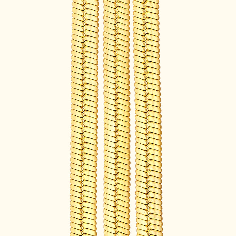 Three gold chains arranged vertically against a light background.
