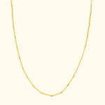 Yellow gold chain necklace with alternating link shapes on a light background.
