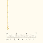 Gold link chain necklace displayed with a measuring ruler for size reference.