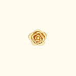 Gold flower-shaped ring with layered petals on a light background.
