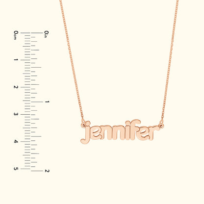 Rose gold necklace featuring the name "jennifer" in cursive font, against a light background.