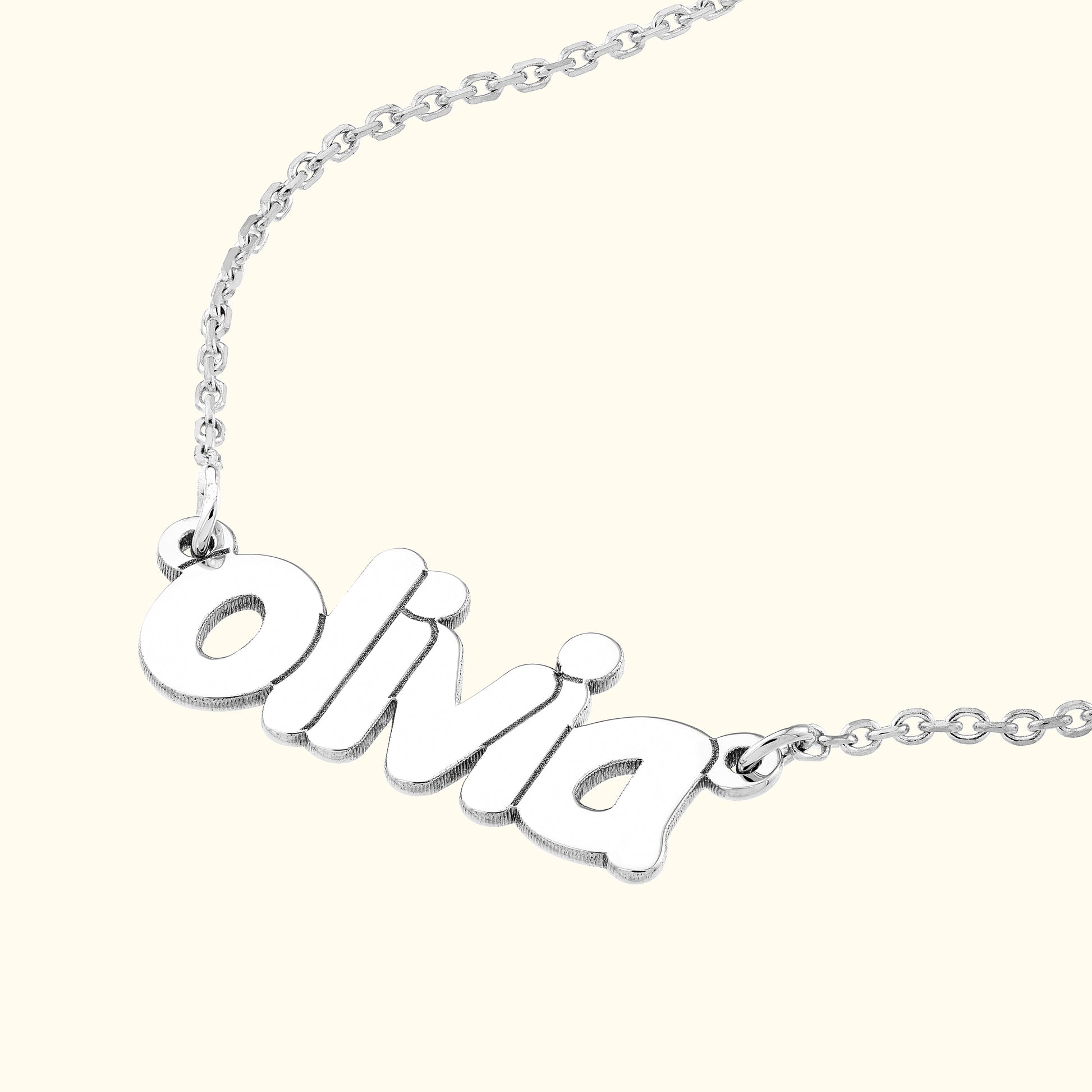 Silver name necklace with the name "Olivia" in a playful font.