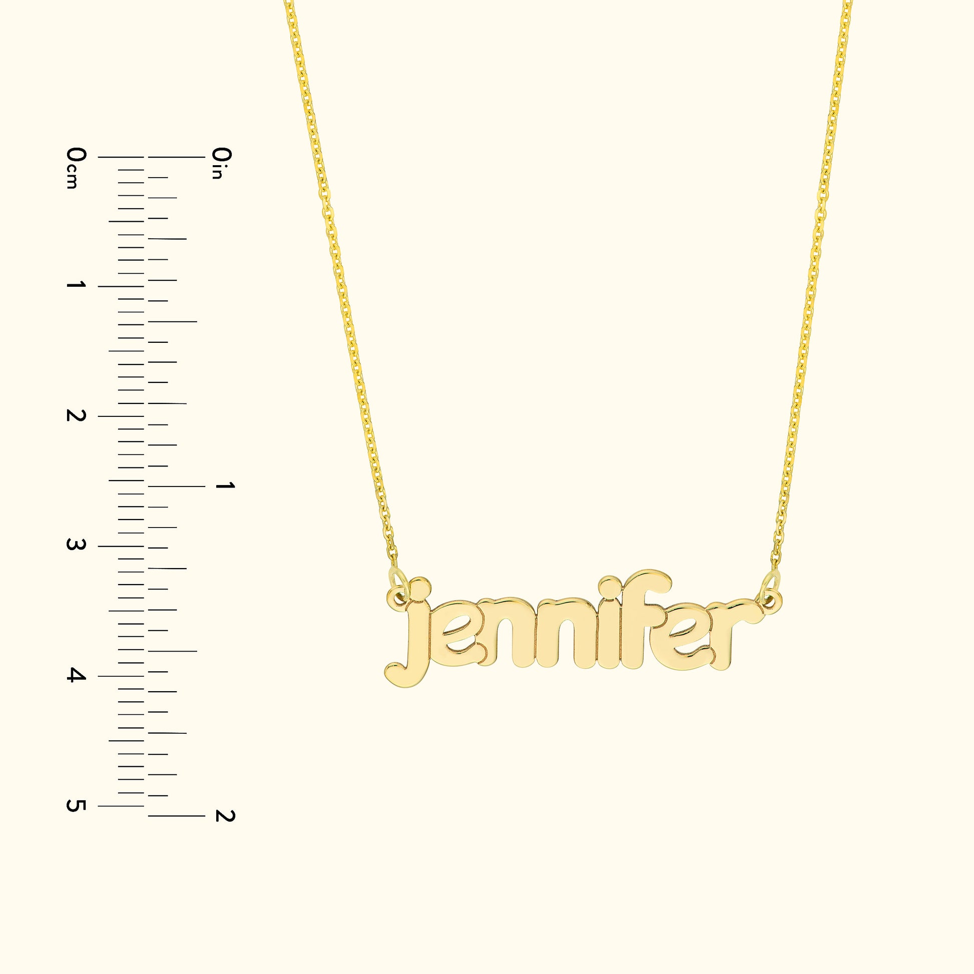 Gold name necklace with the text "jennifer," displayed next to a ruler for size reference.