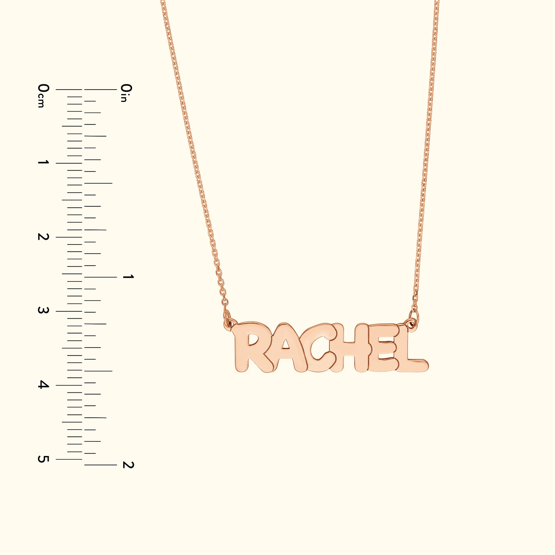 Rose gold necklace with the name "RACHEL" in bold, playful lettering.