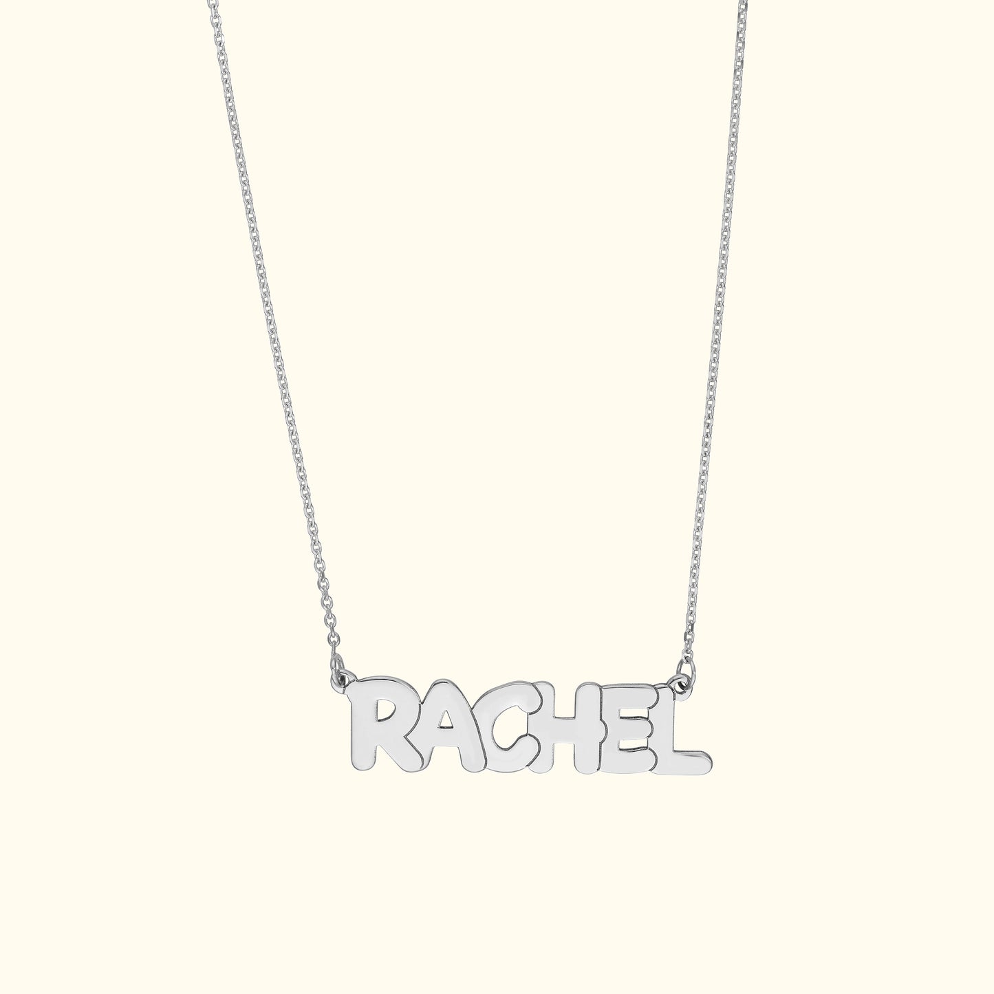 Silver name necklace spelling "RACHEL" on a delicate chain.