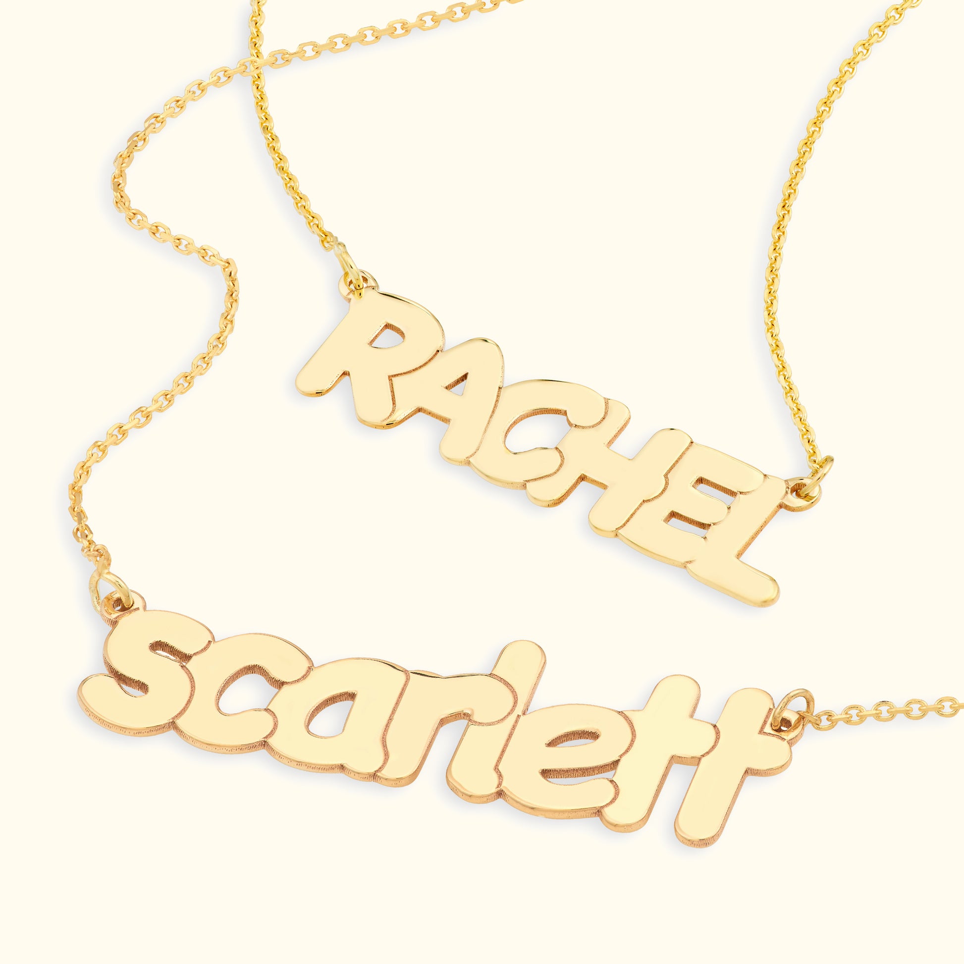 Gold name necklaces displaying the names "RACHEL" and "scarlett" in playful font.