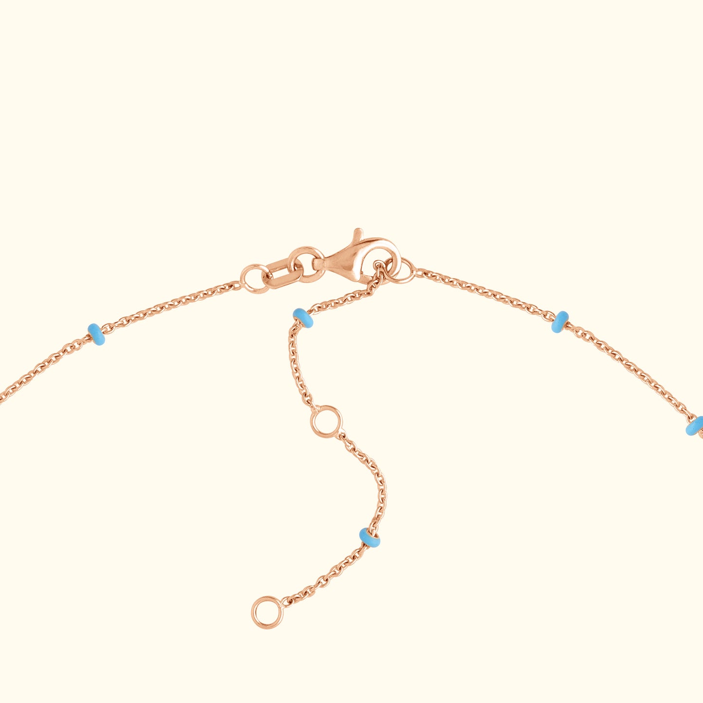 Rose gold bracelet chain with small turquoise beads and a lobster clasp.