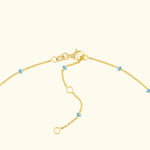 Gold bracelet with blue accent beads and a lobster clasp fastening.