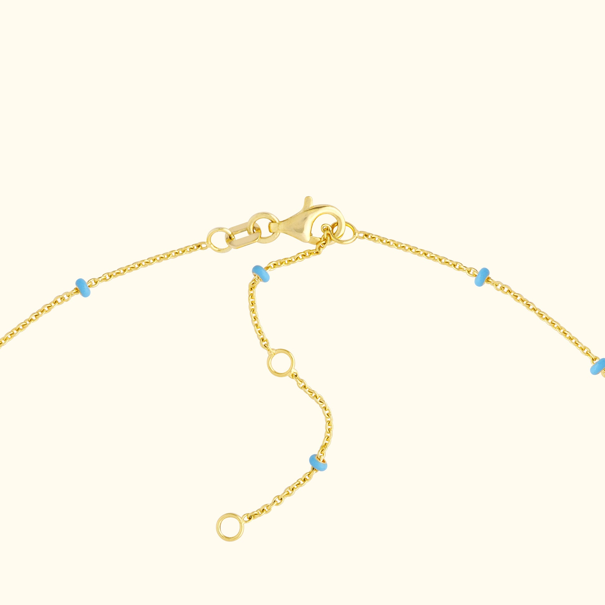 Gold bracelet with blue accent beads and a lobster clasp fastening.