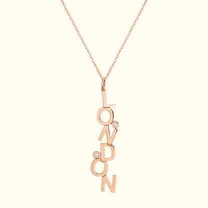 Rose gold pendant necklace featuring "LONDON" with two small diamonds.