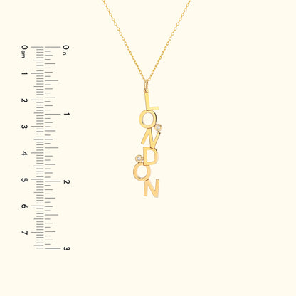 Gold necklace featuring "LONDON" letters with two small diamonds.