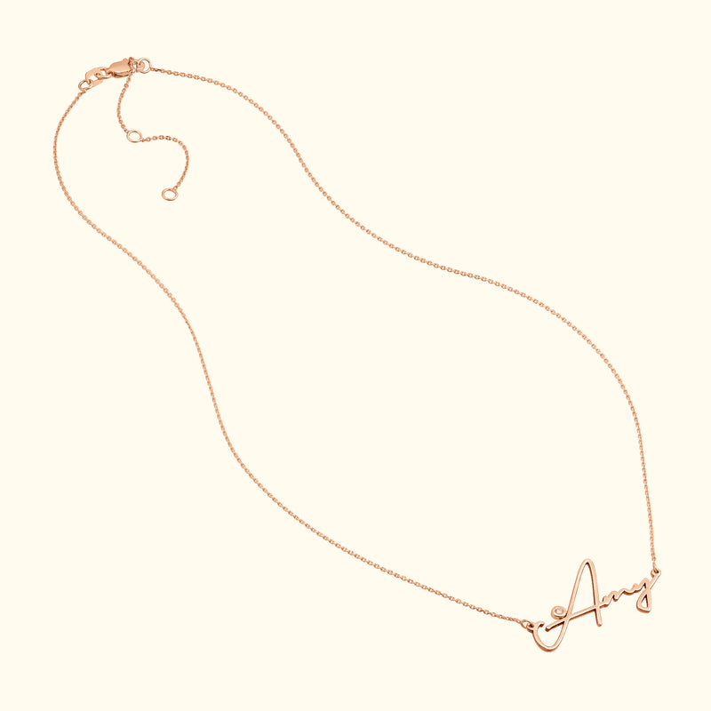 Delicate rose gold necklace featuring a cursive letter "A" pendant.