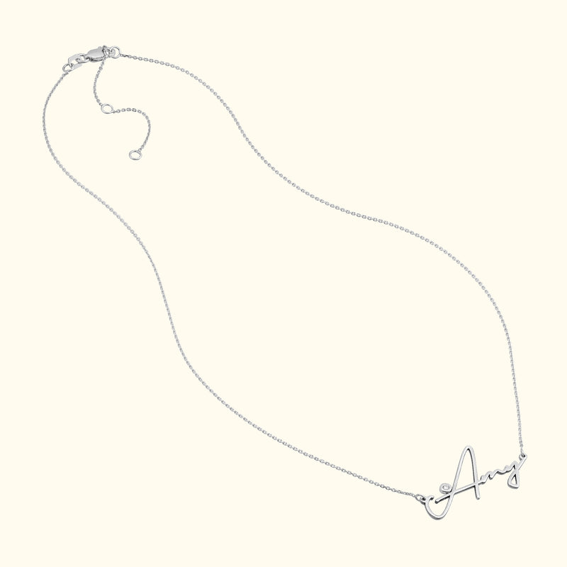 Silver necklace with a cursive letter "A" pendant.