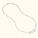 Silver chain necklace with rectangular tag pendant.