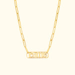 Gold chain necklace featuring a rectangular pendant with engraved letters and a small diamond.
