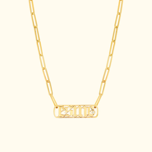 Gold chain necklace featuring a rectangular pendant with engraved letters and a small diamond.