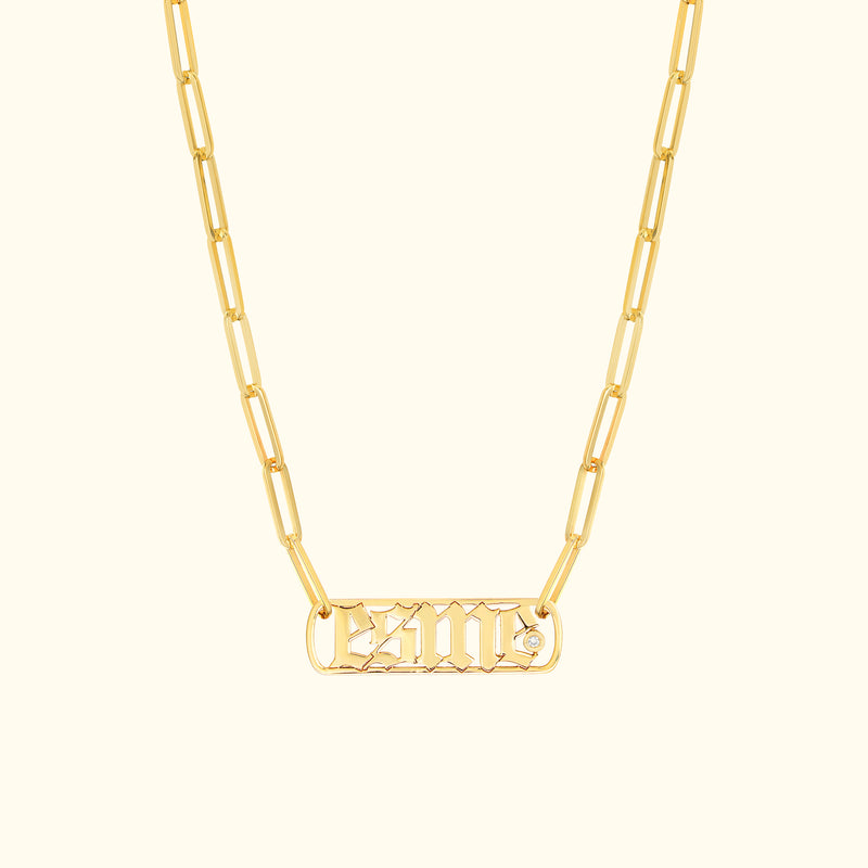 Gold chain necklace featuring a rectangular pendant with engraved letters and a small diamond.
