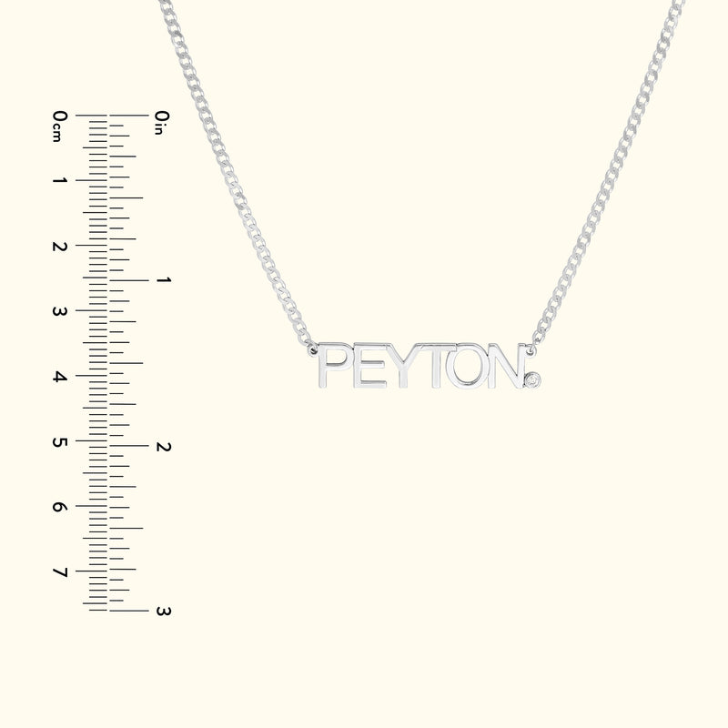 Silver necklace with a nameplate reading "PEYTON," alongside a ruler for scale.