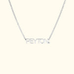 Silver name necklace featuring the name "PEYTON" with a small diamond accent.
