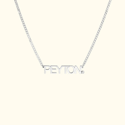 Silver name necklace featuring the name "PEYTON" with a small diamond accent.