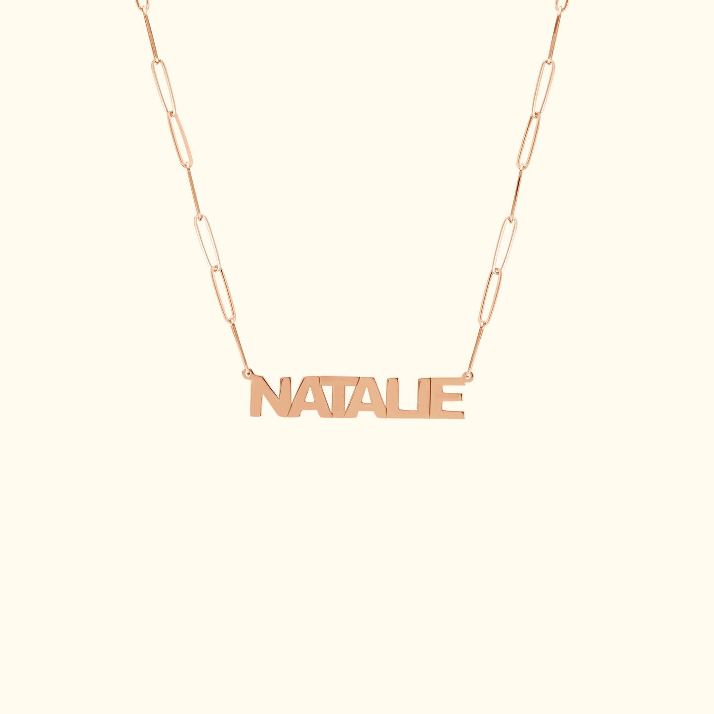 Rose gold name necklace with the word "NATALIE" on a delicate chain.