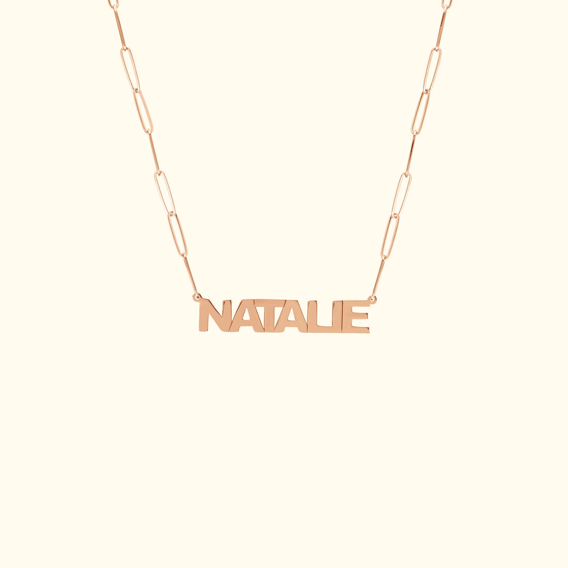 Rose gold name necklace with the word "NATALIE" on a delicate chain.