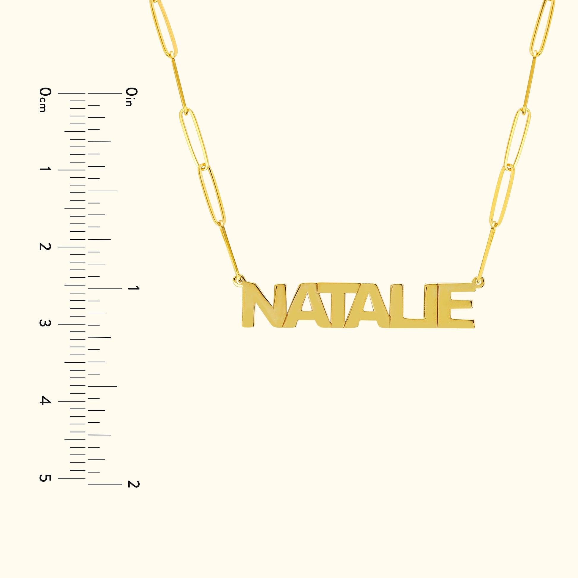 Gold name necklace with the word "NATALIE," next to a ruler for size reference.