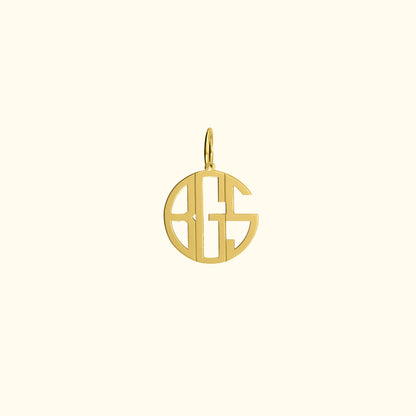 Gold pendant featuring a stylized monogram within a circular design.